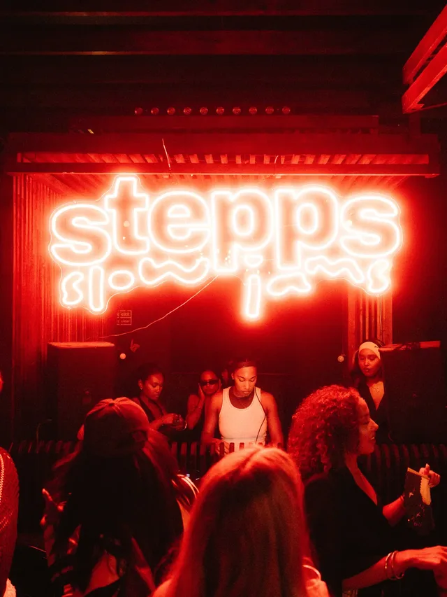 A Stepps Slow Jams dance floor glowing under the red neon Stepps sign.