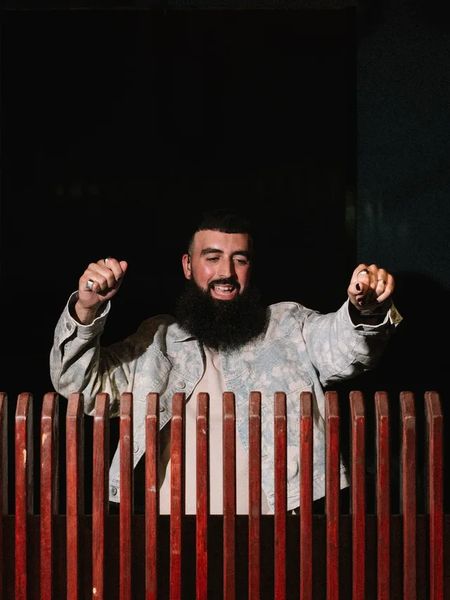 An attendee dancing with his hands raised.